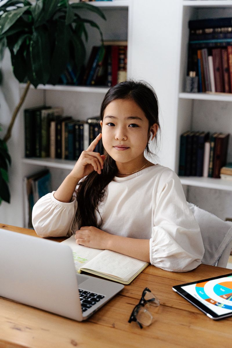 Student at her desk with a laptop and study notes